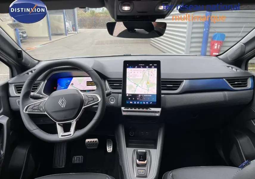 Vue intérieure frontale du Renault Symbioz 2026, tableau de bord gris avec écran tactile vertical et volant multifonction.