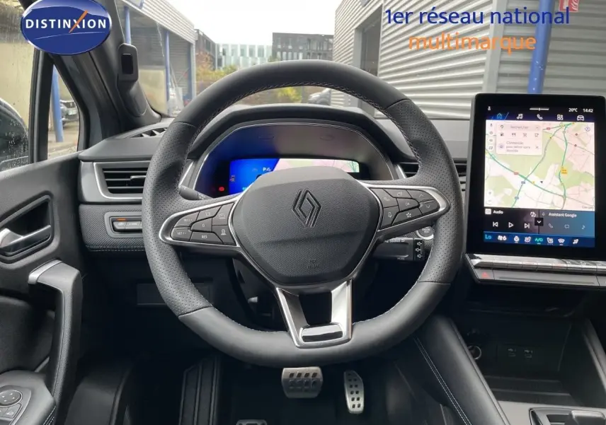 Vue frontale de l'intérieur du Renault Symbioz gris Rafale, volant multifonction et écran tactile avec navigation affichée.