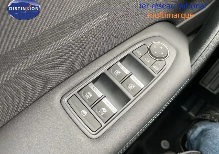 Gros plan sur les commandes de lève-vitres côté gauche avec surpiqûres bleues dans l’habitacle noir du Renault Symbioz gris Rafale.
