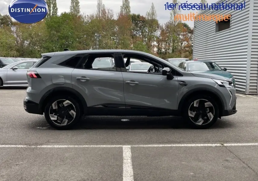 Vue latérale droite d'un Renault Symbioz gris rafale métal, SUV hybride avec jantes noires et détails modernes.