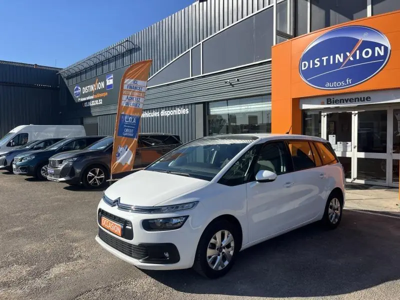 Citroën Grand C4 Spacetourer blanc Banquise vu en 3/4 avant droit devant un concessionnaire Distinxion.
