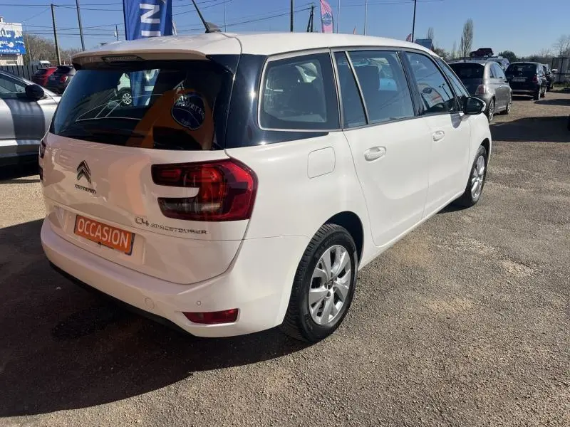 Vue 3/4 arrière droite d'un Citroën Grand C4 Spacetourer blanc Banquise avec jantes alliage et toit noir.