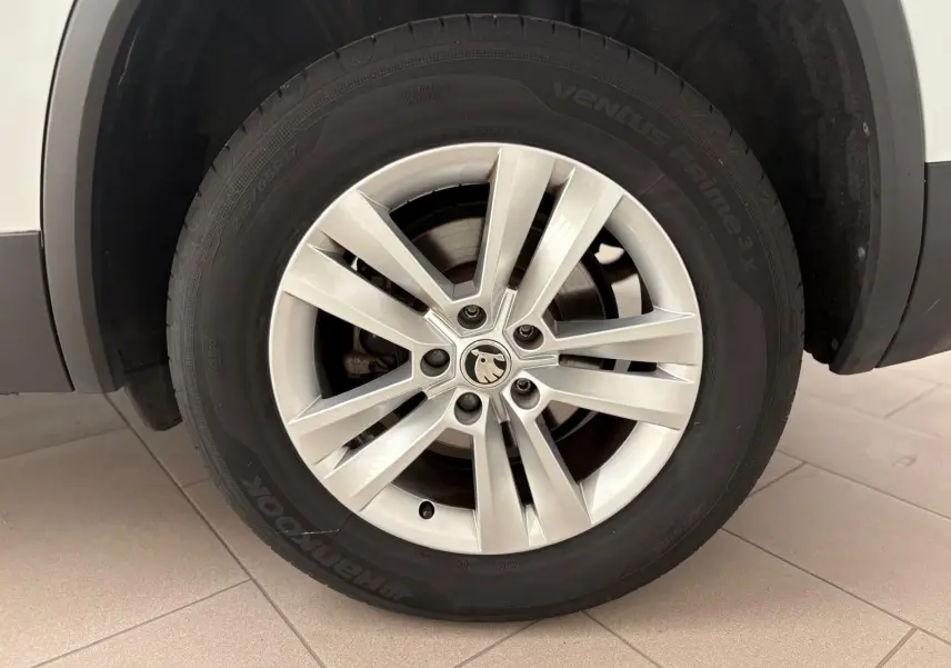 Gros plan sur la roue avant droite blanche lune d'un Skoda Kodiaq 2022 avec jante alliage et logo central visible.