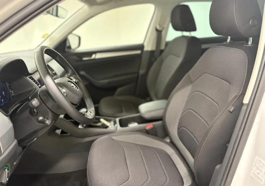 Intérieur vu côté conducteur du Skoda Kodiaq blanc lune 2022, sièges tissu gris et tableau de bord avec Digital Cockpit.