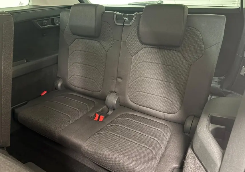 Vue rapprochée de la troisième rangée de sièges noirs du Skoda Kodiaq 2022, avec banquette rabattable et ceintures rouges.