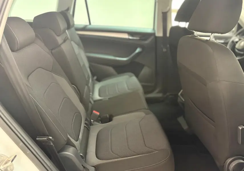 Vue intérieure côté gauche sur la banquette arrière noire du Skoda Kodiaq blanc Lune 2022 avec finitions sobres.