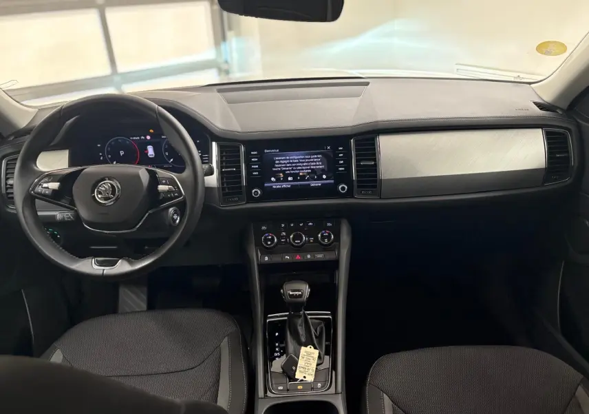 Intérieur du Skoda Kodiaq 2022 vu de face, tableau de bord noir avec écran tactile et volant multifonction.