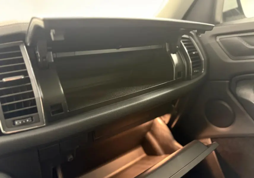Intérieur du Skoda Kodiaq 2022, vue sur la boîte à gants ouverte côté passager avec éclairage ambiant doux.