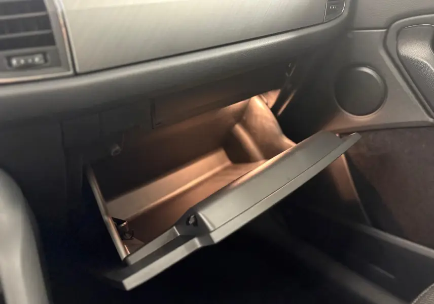 Intérieur du SKODA KODIAQ 2022 vue côté passager sur la boîte à gants ouverte avec éclairage intérieur doux.