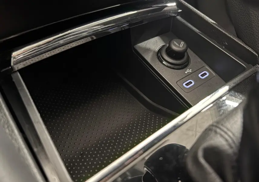 Gros plan sur la console centrale du Skoda Kodiaq blanc, montrant les ports USB et allume-cigare.