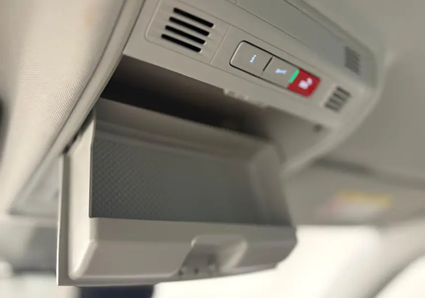 Rangement lunettes ouvert sous le plafonnier gris clair dans l'habitacle du Skoda Kodiaq blanc lune.