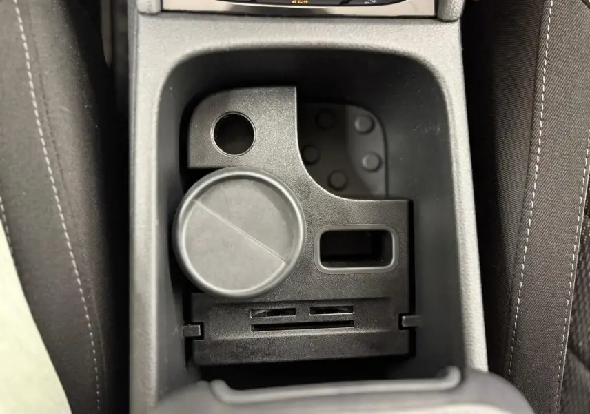 Gros plan sur le rangement central noir entre les sièges avant du Skoda Kodiaq blanc Lune 2022.