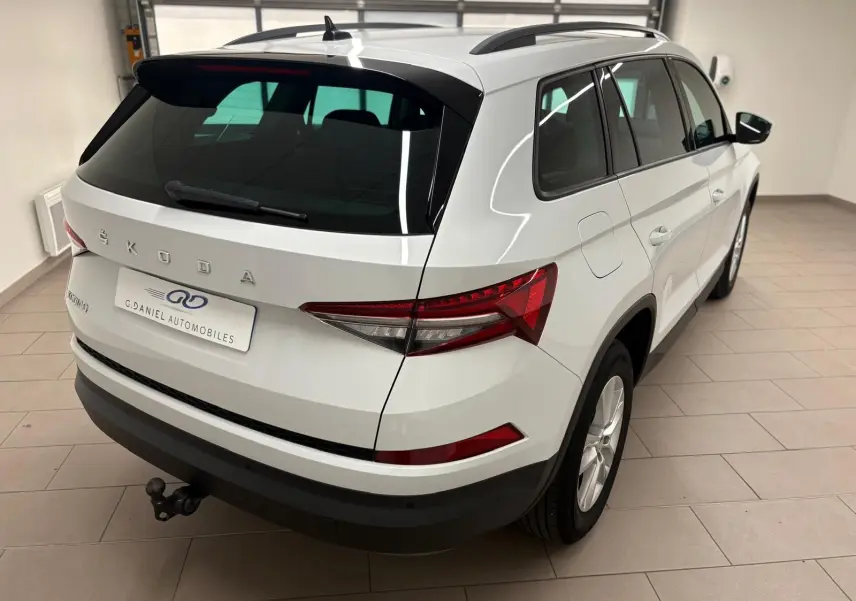 Vue 3/4 arrière droite du Skoda Kodiaq blanc lune 2022 avec crochet d'attelage escamotable et vitres teintées.