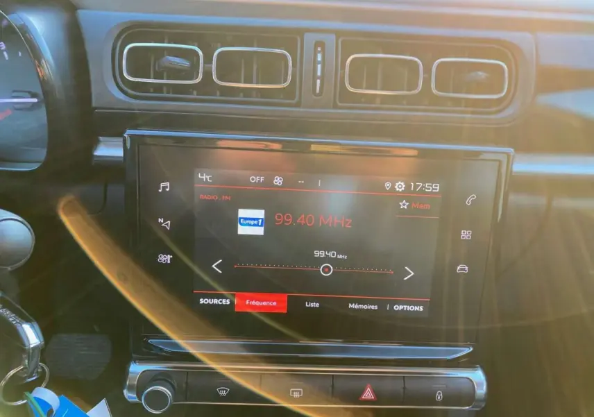 Vue rapprochée de l'écran tactile central et des aérateurs d'une Citroën C3 Shine 2023 noir toit rouge, intérieur moderne.