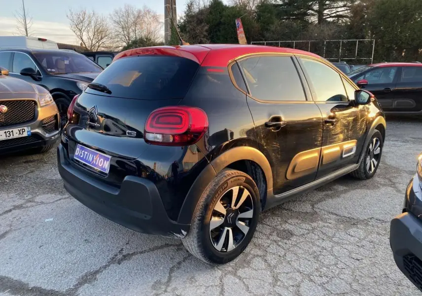Citroën C3 Shine 2023 noir avec toit rouge, vue 3/4 arrière droit, jantes alliage et vitres surteintées.