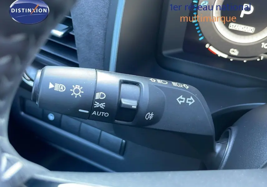 Gros plan sur la commande des feux et clignotants du Nissan Qashqai 2025, intérieur noir moderne.