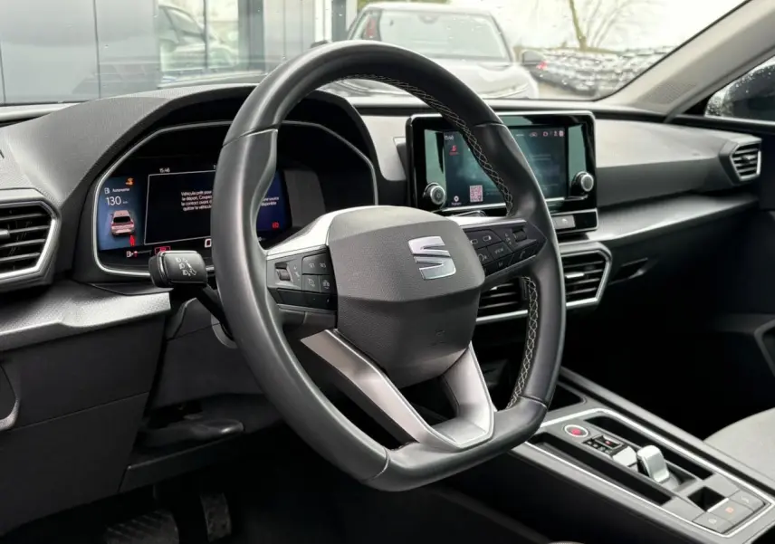 Vue intérieure centrée sur le volant cuir multifonction et le tableau de bord digital du SEAT Leon 2024.