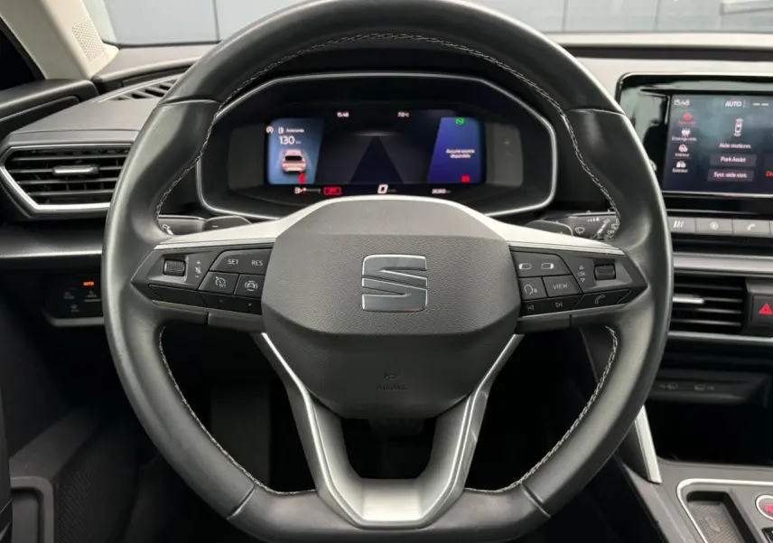 Vue rapprochée du volant cuir multifonction de la SEAT LEON 2024 avec tableau de bord digital et écran central tactile.