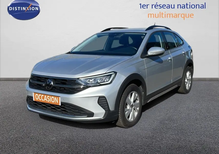 Volkswagen Taigo 1.0 TSI 110ch Life Business en reflet d'argent métal, vue 3/4 avant droit sur sol gris.
