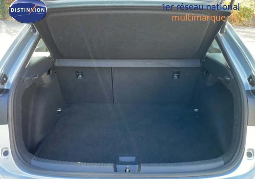 Coffre ouvert vu de l'arrière d'un Volkswagen Taigo 2022 couleur reflet d'argent métal, espace de chargement vide et propre.