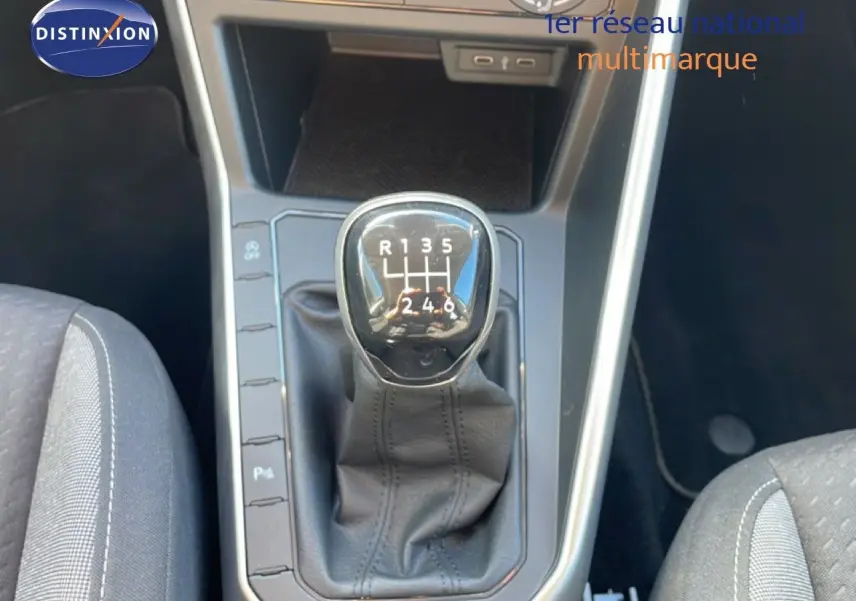 Gros plan sur le levier de vitesses manuel du Volkswagen Taigo 2022 couleur reflet d'argent métal, intérieur tissu gris.