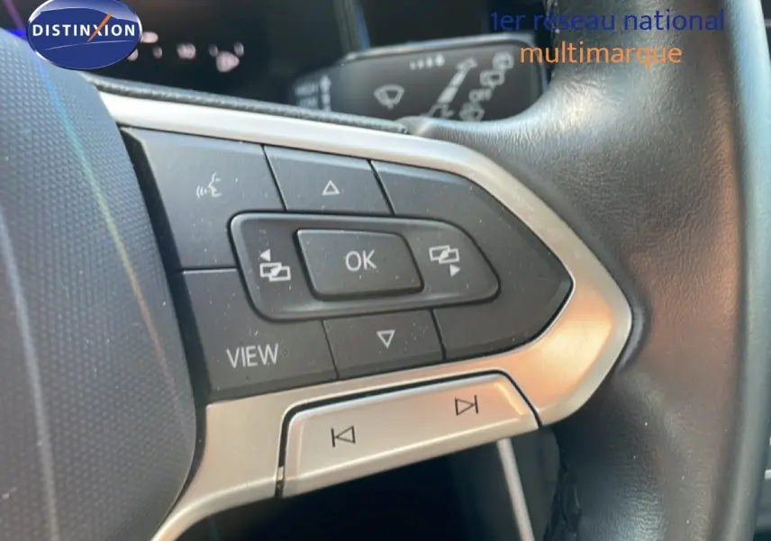 Gros plan sur les commandes multifonctions à gauche du volant en cuir noir du Volkswagen Taigo 2022.