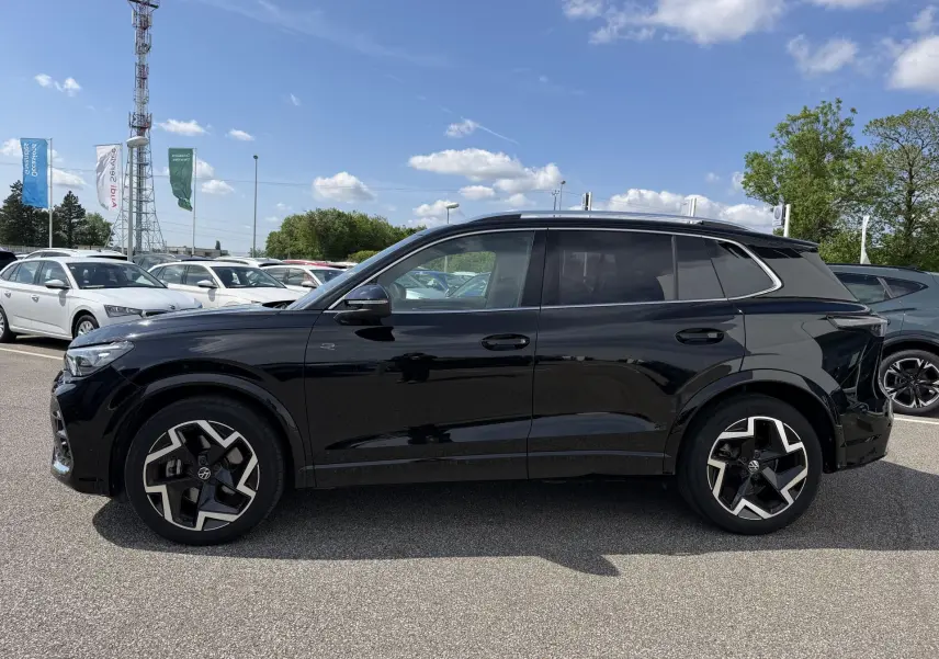 Volkswagen Tiguan noir vu de profil côté gauche avec jantes alliage 19 pouces et toit noir brillant.