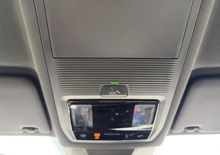 Vue en plongée sur le plafonnier gris avec bouton SOS et éclairages intérieurs du Volkswagen Tiguan noir 2025.