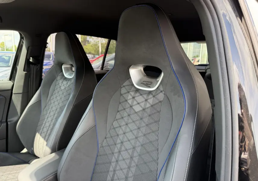 Gros plan sur les sièges avant sport gris avec surpiqûres bleues du Volkswagen Tiguan 2025 côté conducteur et passager.