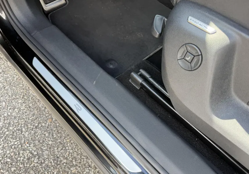 Détail de la porte côté conducteur du Volkswagen Tiguan noir 2025 avec seuil de porte R et siège ErgoActive.