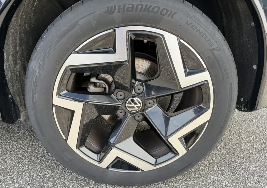 Gros plan sur la jante alliage 19 pouces noire et argentée du Volkswagen Tiguan 2.0 TDI 2025, avec logo VW central.