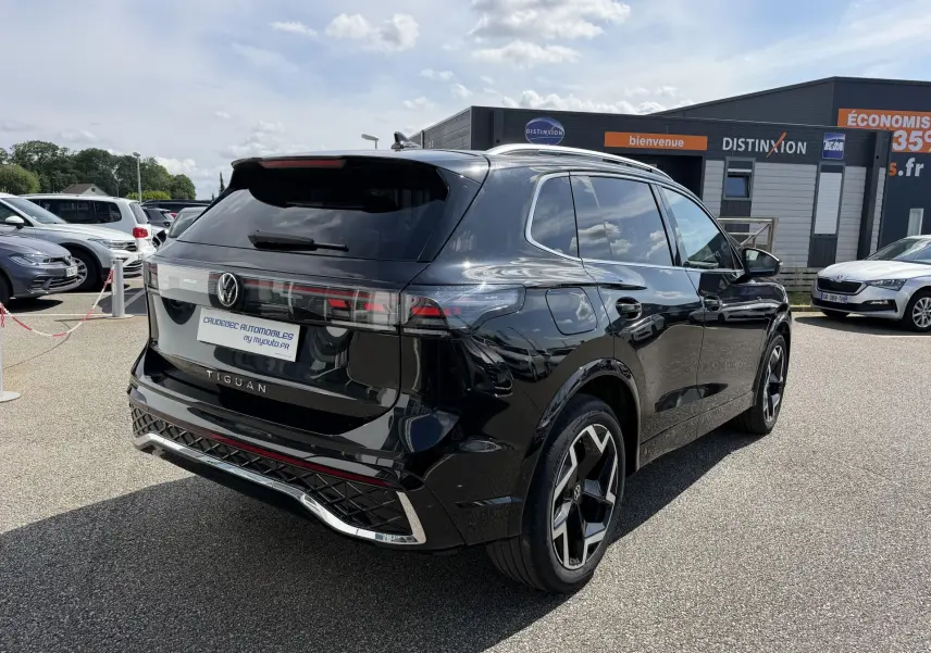Volkswagen Tiguan noir vu en 3/4 arrière droit, avec feux arrière LED 3D et jantes alliage noir et argent.