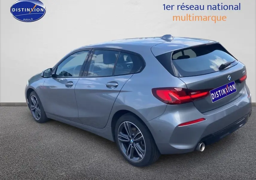 BMW Série 1 gris foncé vue 3/4 arrière côté gauche avec jantes alliage et feux arrière LED distinctifs