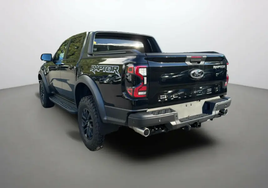 Ford Ranger Raptor noir absolu vu en 3/4 arrière droit, avec logo Raptor et double sortie d'échappement visible.