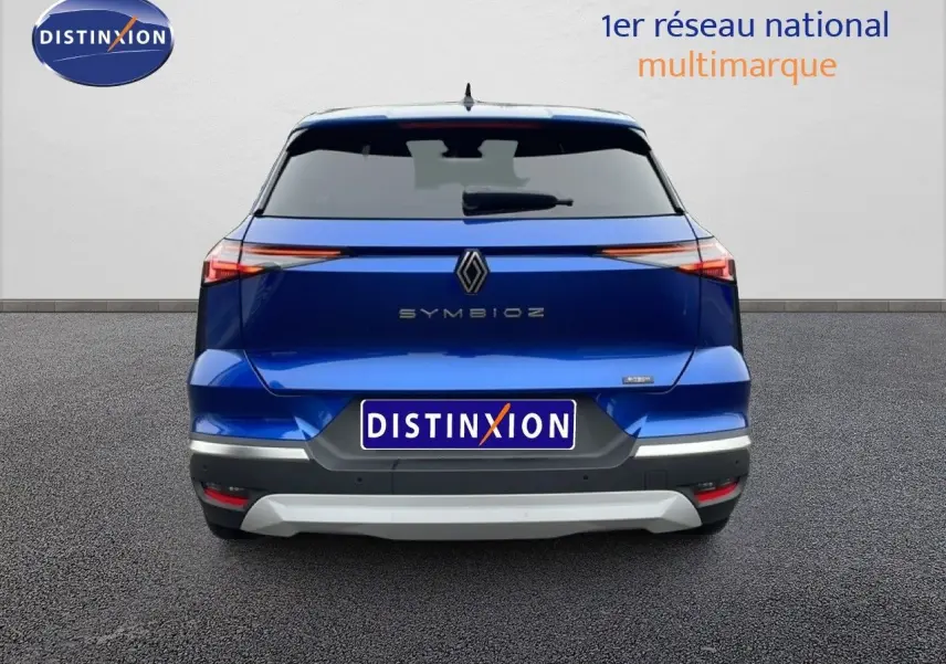 Vue arrière d'une Renault Symbioz bleu Iron Metal avec feux LED fins et logo centré sur fond clair.