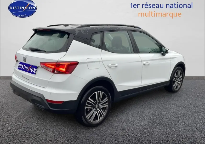 Vue 3/4 arrière droite du SEAT Arona blanc Nevada avec toit noir et jantes 17 pouces Urban Design.