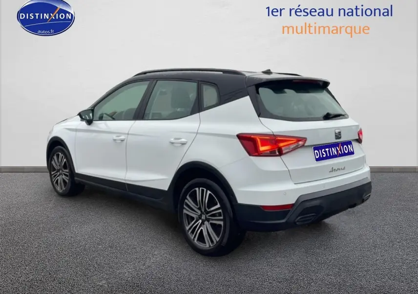 Vue 3/4 arrière droite d'un SEAT Arona blanc Nevada avec toit noir et jantes 17 pouces Urban Design.