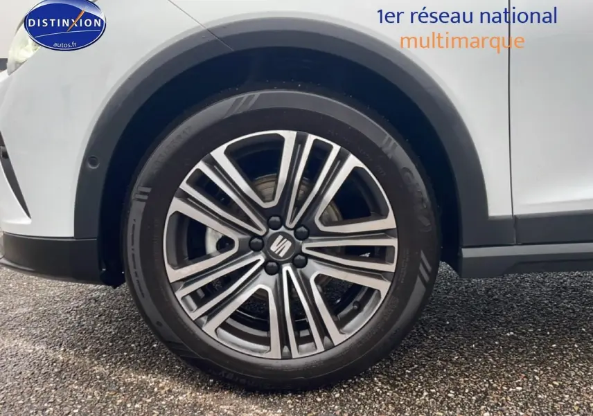 Gros plan sur la roue avant droite d’un SEAT Arona blanc Nevada avec jante 17 pouces Urban Design.