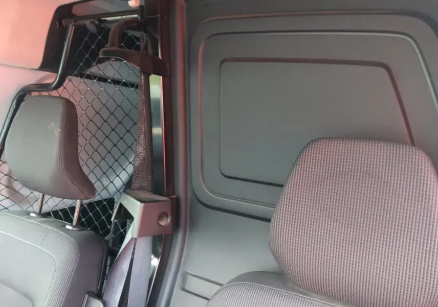 Vue intérieure côté droit du Renault Kangoo 2022, montrant la cloison pivotante et les sièges gris foncé.