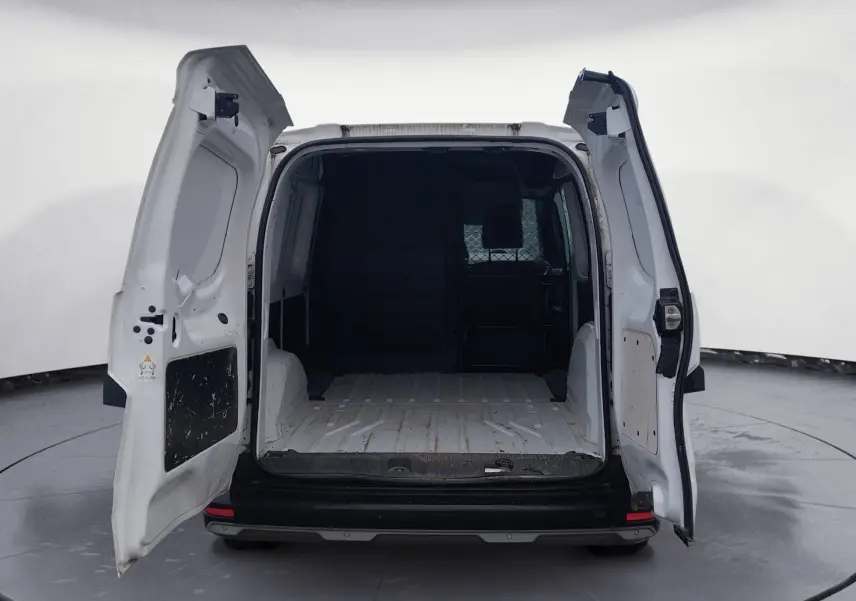 Vue arrière d’un Renault Kangoo blanc 2022 avec portes arrière ouvertes montrant l’espace de chargement vide et cloison pivotante.