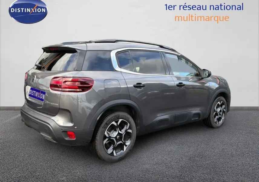 Vue 3/4 arrière droite d’un Citroën C5 Aircross gris platinium métallisé avec toit noir et jantes bi-ton.