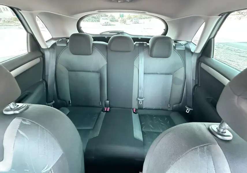 Vue intérieure arrière de la Citroën C4 2011, montrant les sièges arrière en tissu noir et les appuie-têtes.