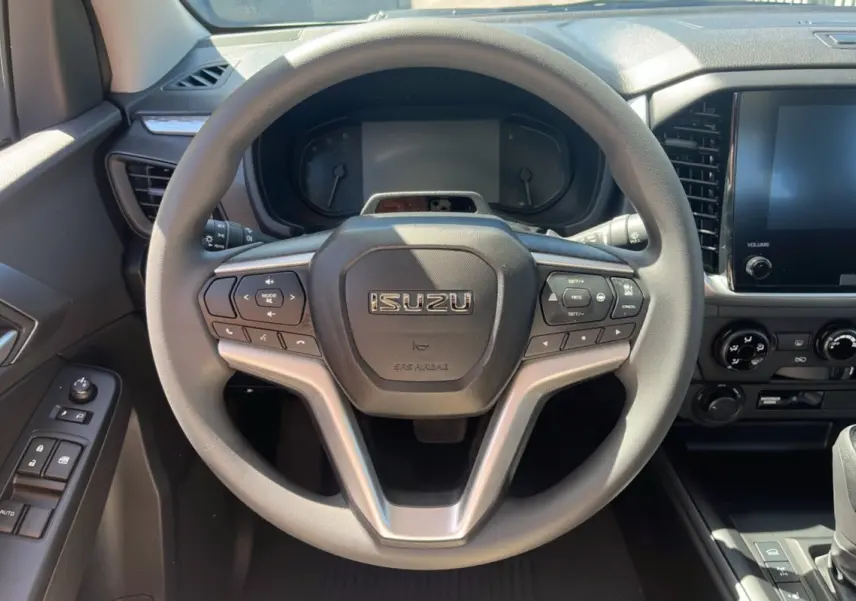 Vue centrée sur le volant multifonctions gris de l'Isuzu D-MAX 2026 avec tableau de bord et écran tactile.