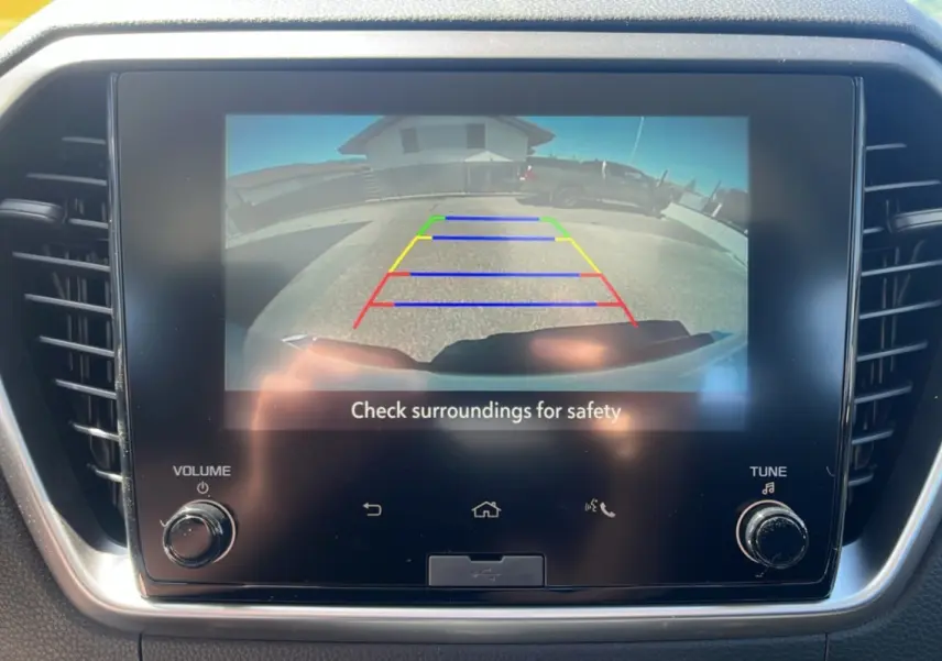Écran tactile intérieur montrant la caméra de recul du pick-up Isuzu D-MAX blanc en stationnement.