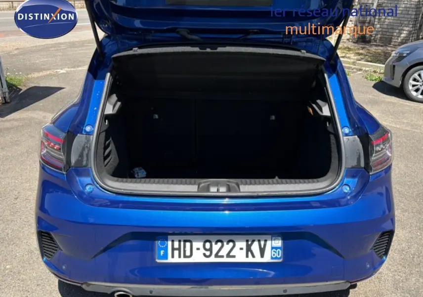 Vue arrière d'une Renault Clio 2025 bleu iron metal avec coffre ouvert, montrant les feux arrière et la plaque d'immatriculation.