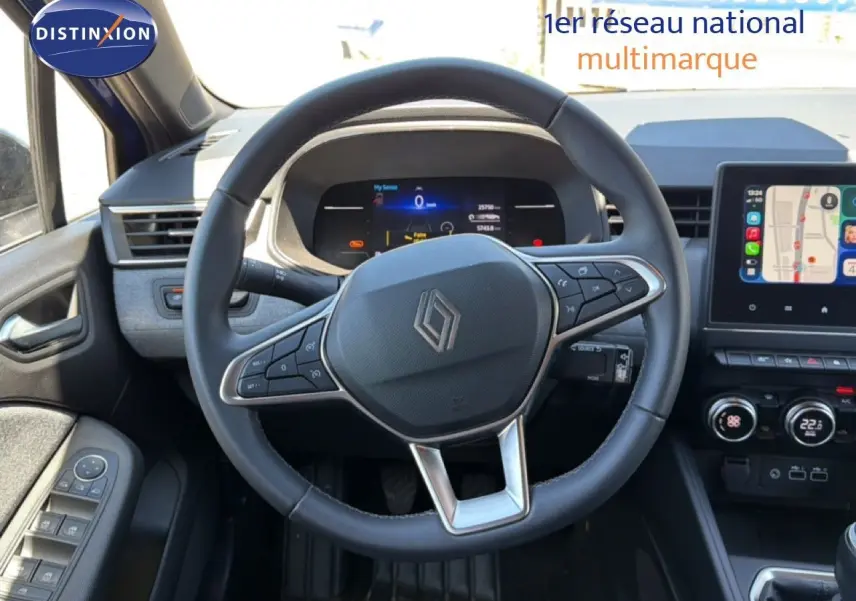 Vue intérieure centrée sur le volant cuir de la Renault Clio 2025, avec tableau de bord digital et écran tactile GPS.