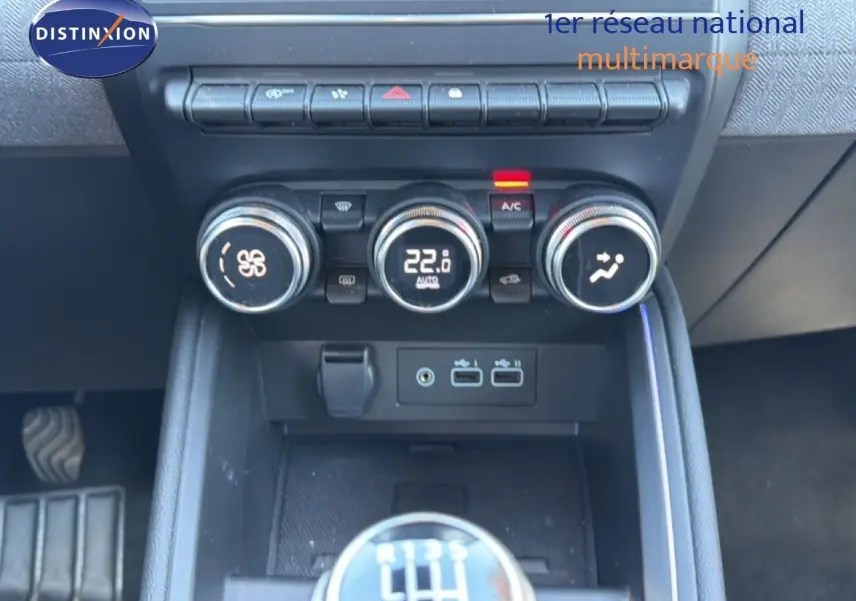 Gros plan sur la console centrale de la Renault Clio 2025, montrant la climatisation digitale et le levier de vitesses manuel.