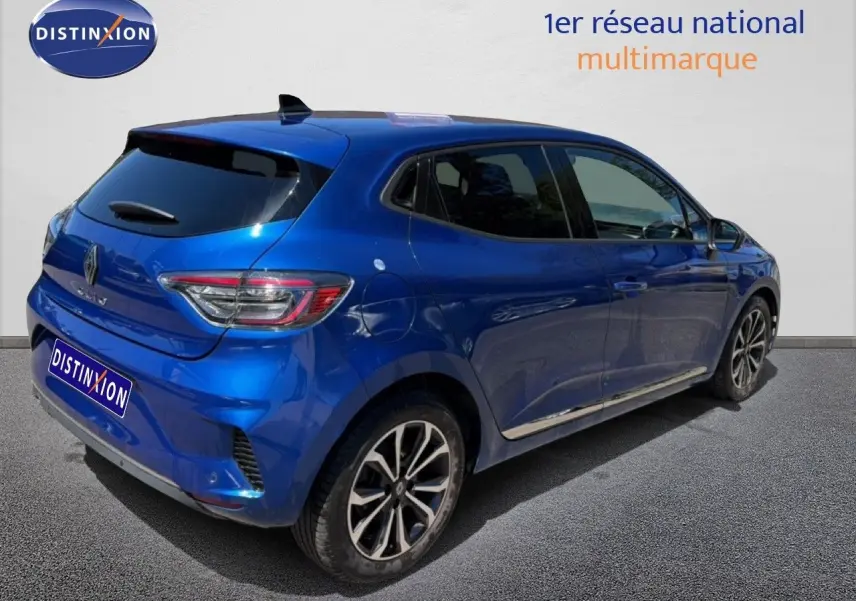 Vue 3/4 arrière droite d'une Renault Clio 2025 bleu iron metal avec jantes alliage et vitres teintées.