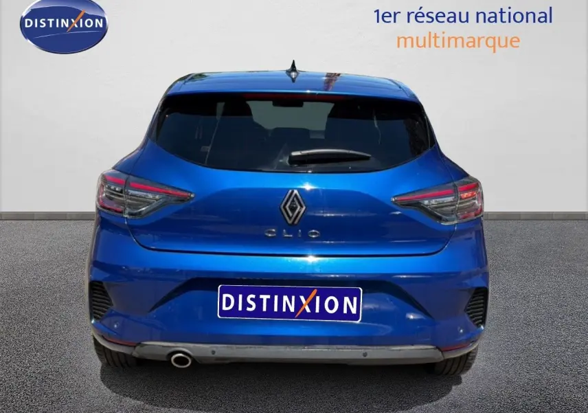 Vue arrière d'une Renault Clio bleu Iron Metal 2025 avec feux LED et sortie d'échappement visible côté gauche.