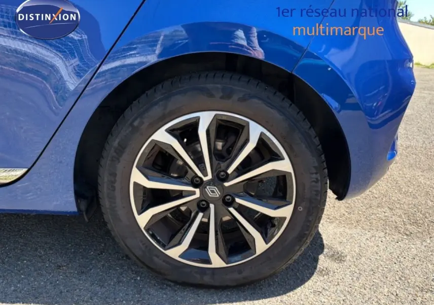 Gros plan sur la roue arrière droite d'une Renault Clio bleu iron metal avec jante alliage 16 pouces design moderne.